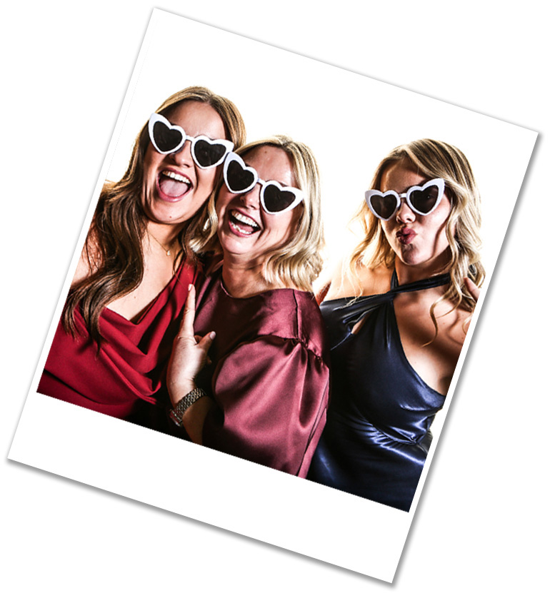 Girl friends at wedding, having their photo taken with fun glasses on