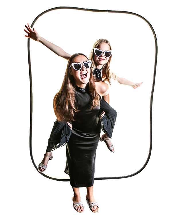 Girls having fun, one is on the back of the other